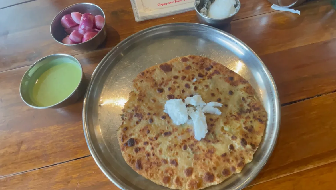 Aloo pyaz tawa paratha with butter and pickled onions at Gulshan Dhaba