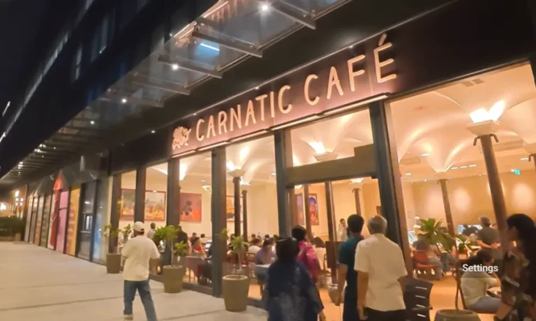 Carnatic Cafe HQ27 exterior at night with diners near the entrance