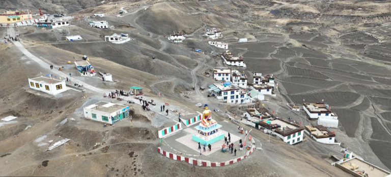 Aerial view of Langza village, Buddha statue, houses and terraced fields in Spiti Valley