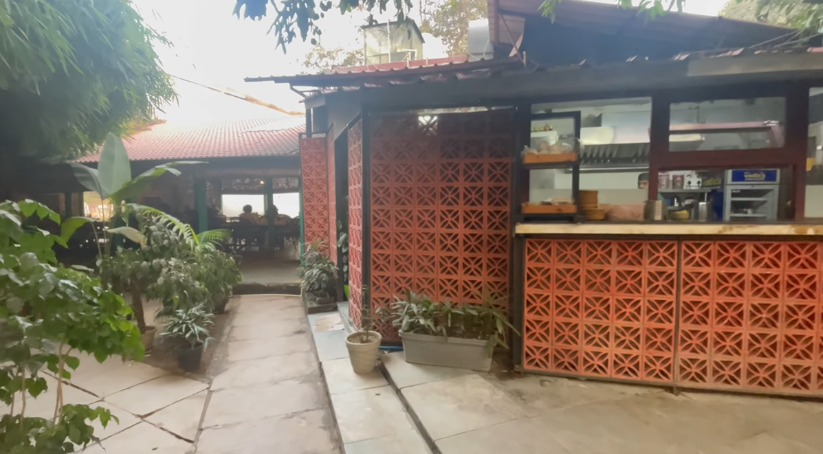 Roots Cafe counter and plant-lined passage connecting the dining areas