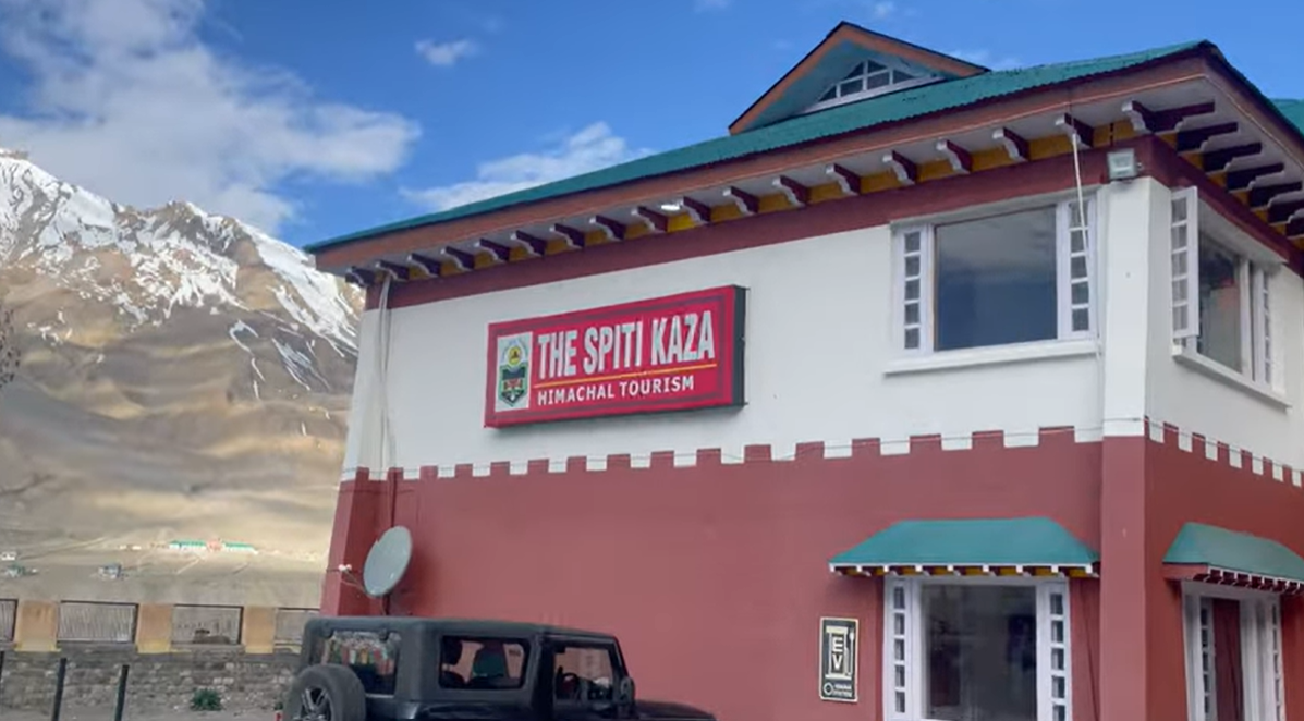 Hotel The Spiti Kaza review showing the Himachal Tourism hotel building and snow-covered mountains