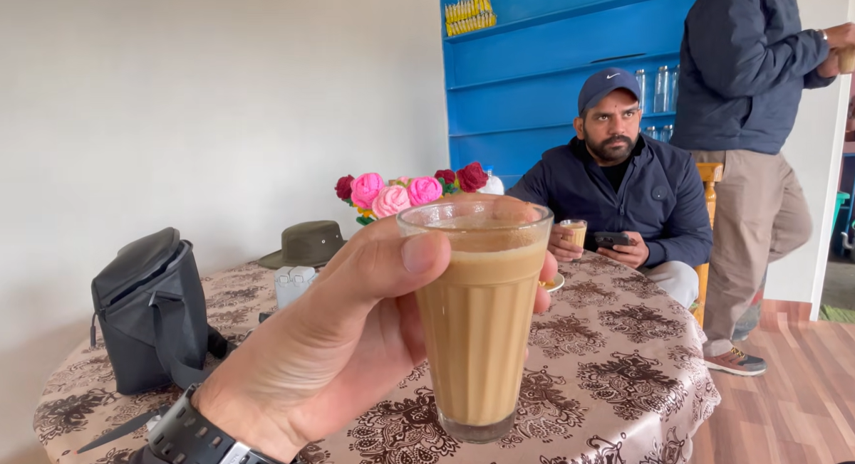 Holding a glass of hot milk tea inside the Spaceship Cafe at Langza