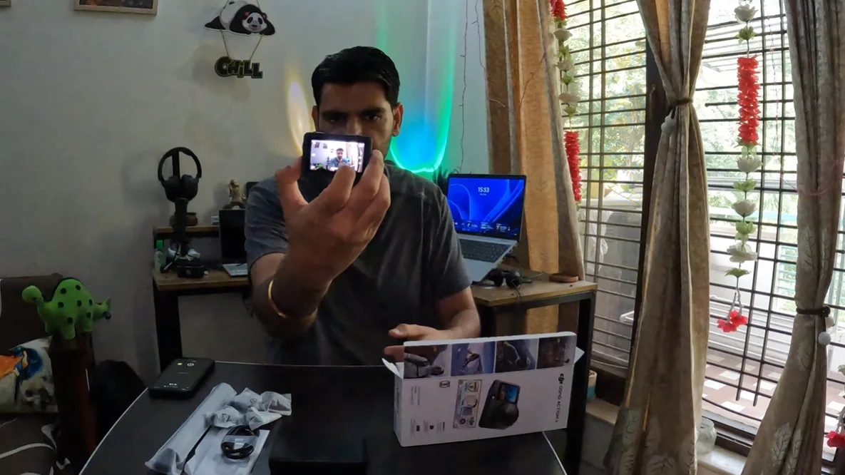 Naveen holding the DJI Osmo Action 6 with its front screen visible during the first look