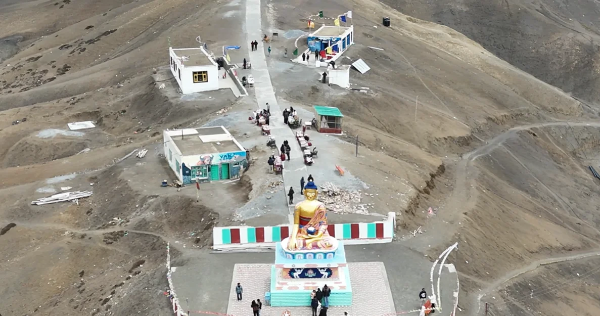 Drone view above the Langza Buddha statue and village path in Spiti