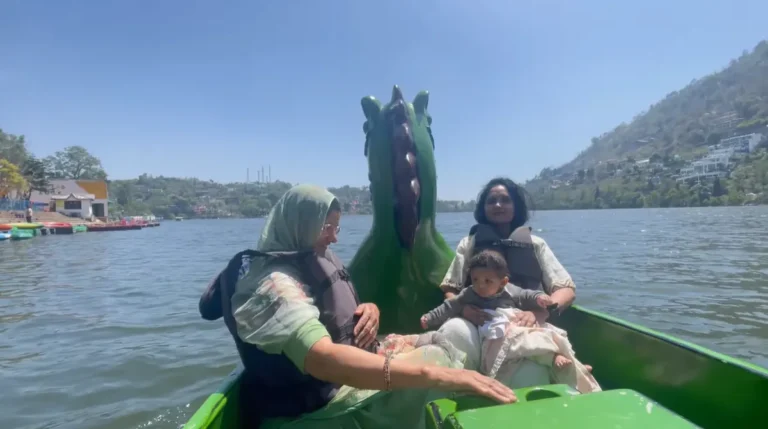 Family boating on Bhimtal Lake with a baby in a life jacket