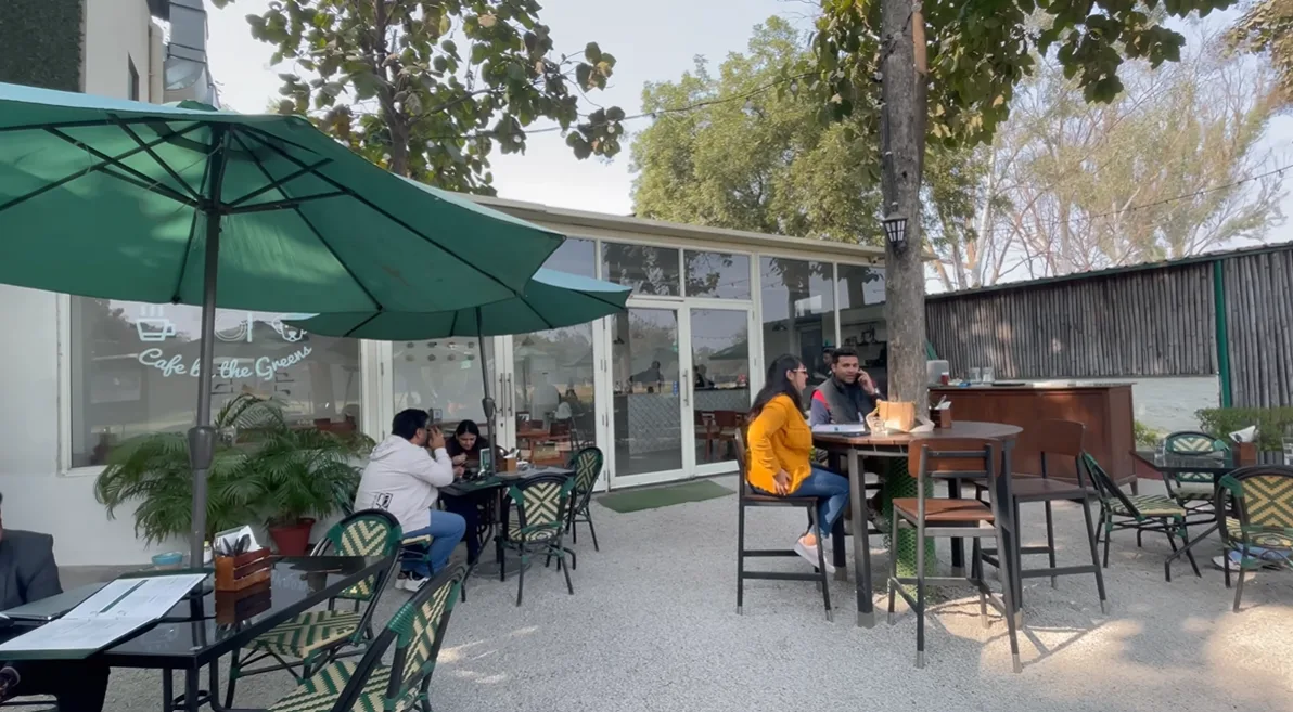 Outdoor seating under trees at Hamoni Cafe by the Greens