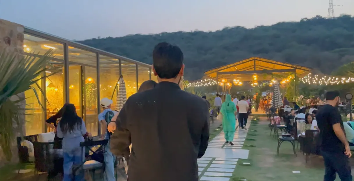 Busy outdoor seating and illuminated walkway at Jugnoo Cafe in the evening