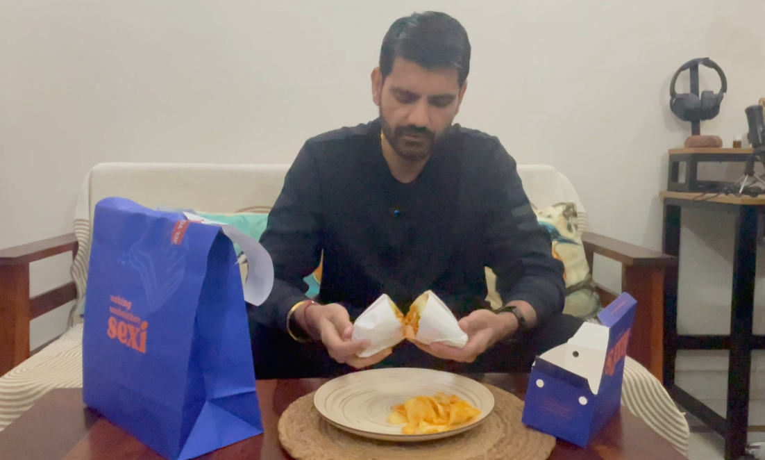 Naveen opening the delivered Lexi's Pesto Grilled Chicken sandwich at home