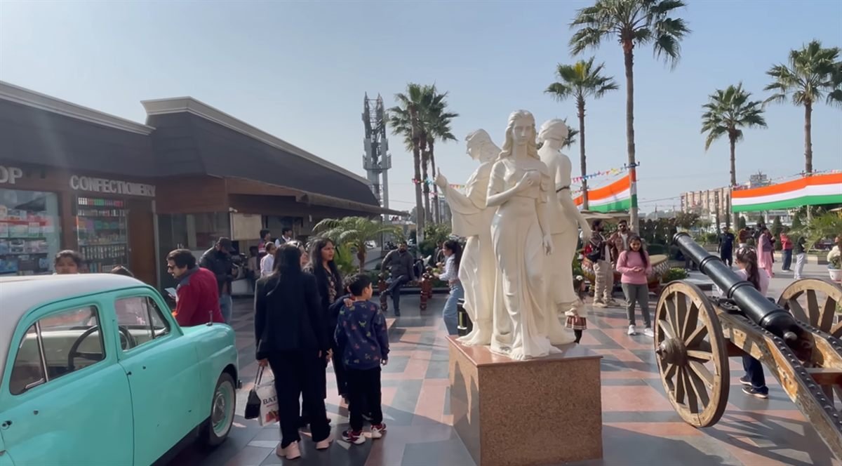 Families near statues, a vintage car and cannon at Mannat Haveli Murthal