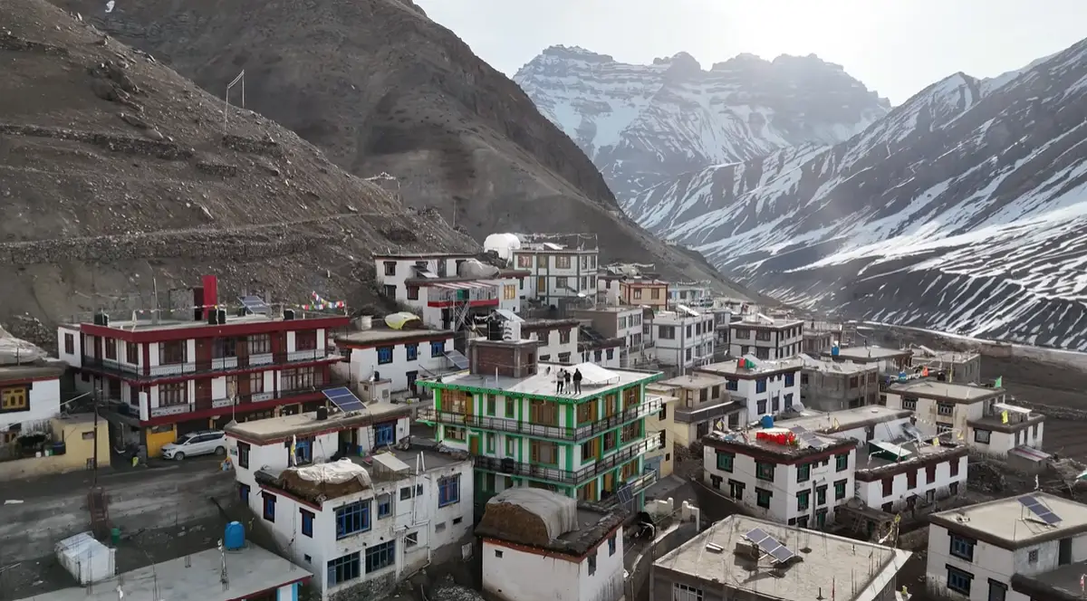 Aerial view of Mudh village homestays beneath snow-covered Pin Valley mountains