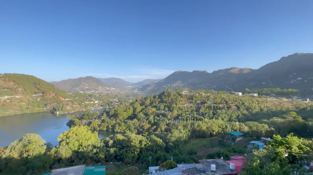 Naukuchiatal Lake surrounded by green hills and houses