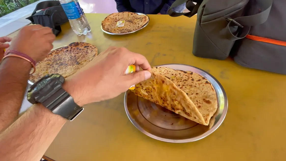 Tawa paratha served on a steel plate during breakfast at Amar Bhojanalaya