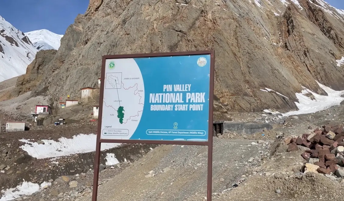 Pin Valley National Park boundary start point sign beside a rocky snow-lined road