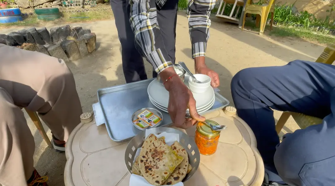 Stuffed parathas with pickle and butter served outdoors at The Monk Kalpa