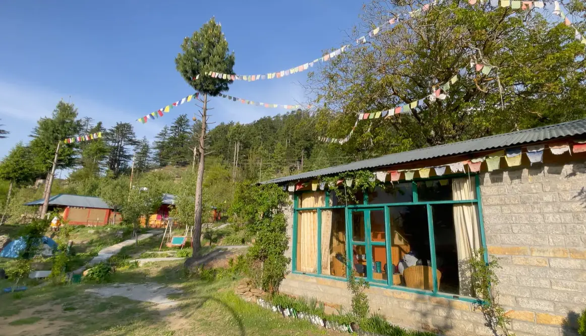 Stone cottage with large green-framed windows in the garden at The Monk Kalpa