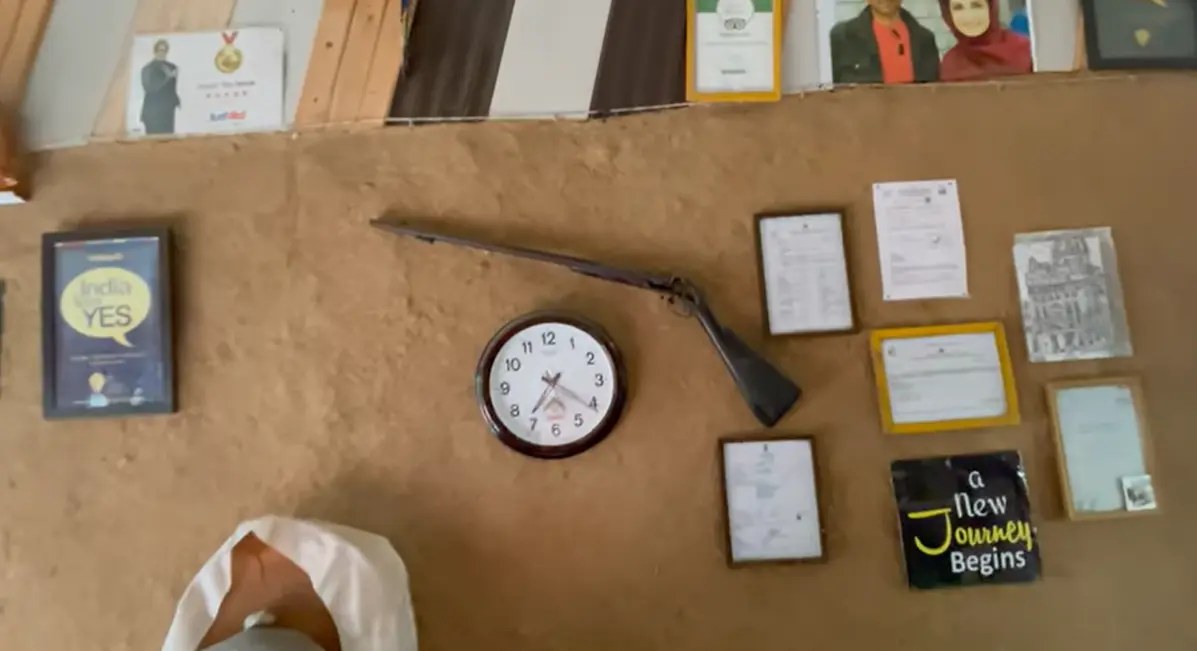 Rustic wall with a clock, old firearm, certificates and travel decor