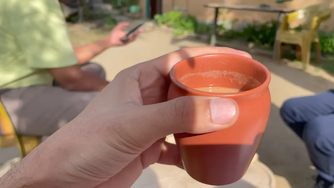 Small clay-coloured cup of tea held outdoors at The Monk Kalpa