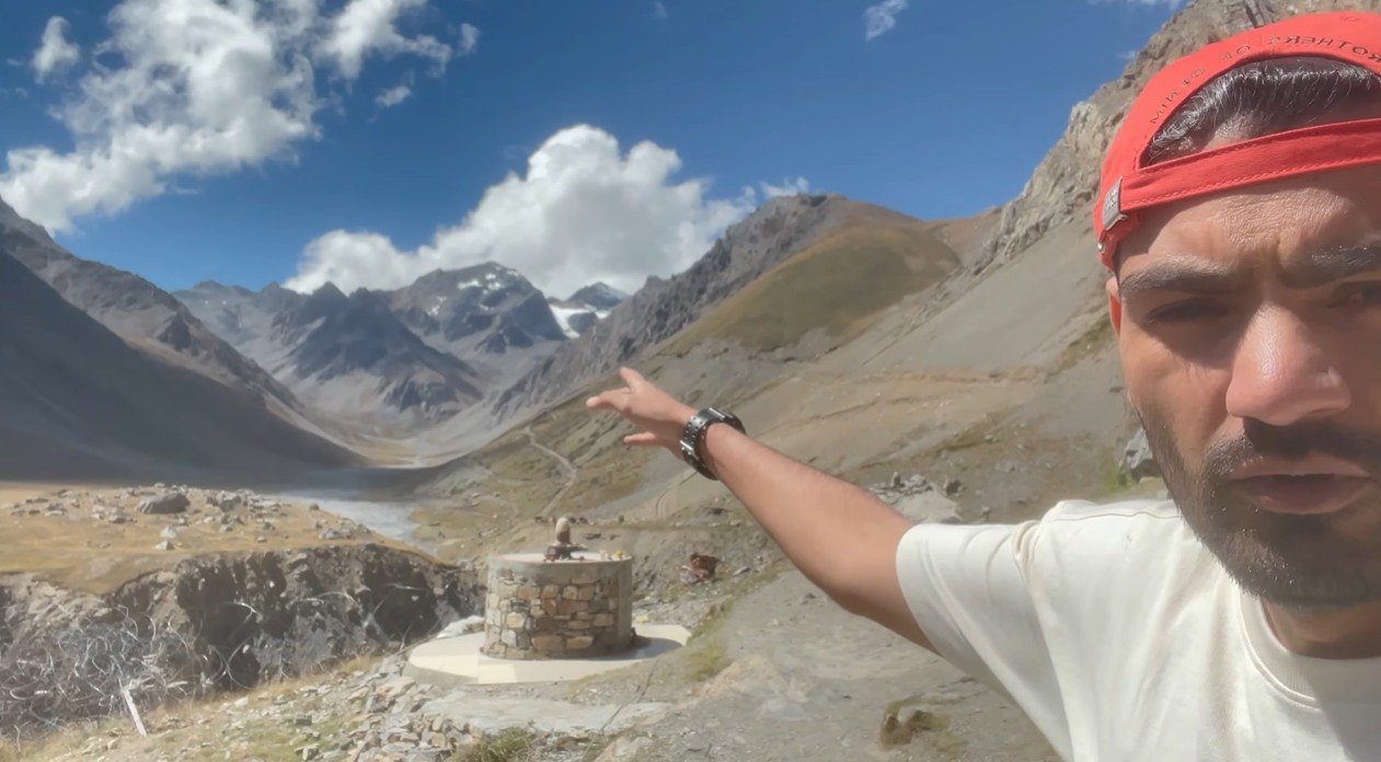 Creator pointing toward the high mountain valley on the Adi Kailash route
