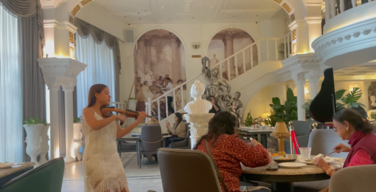 Violinist performing inside the white and gold Begeterre restaurant in Gurgaon