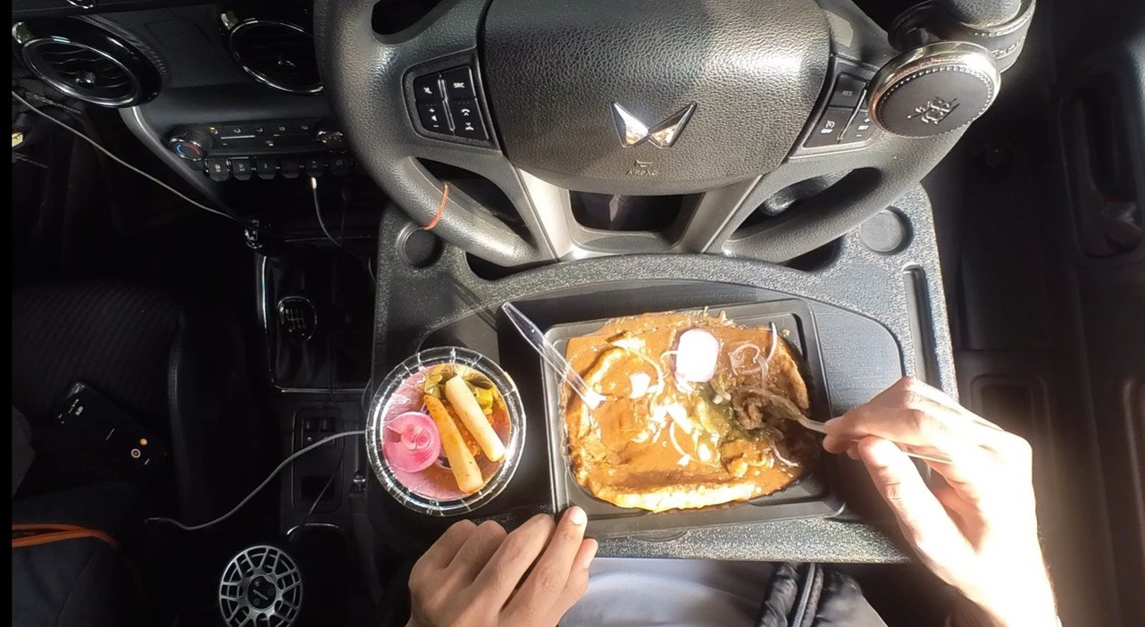 Bheega kulcha and salad on a tray inside the parked car
