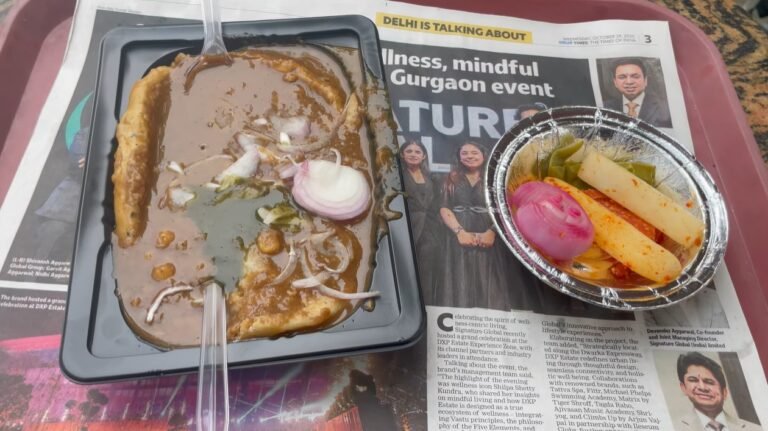 Bheega kulcha covered with chole beside a bowl of radish and onion salad