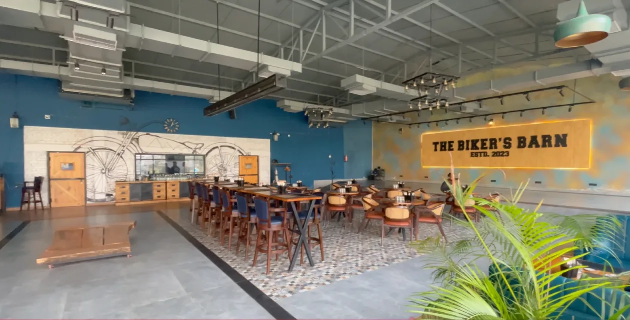 Large dining area with tables and illuminated Biker's Barn sign