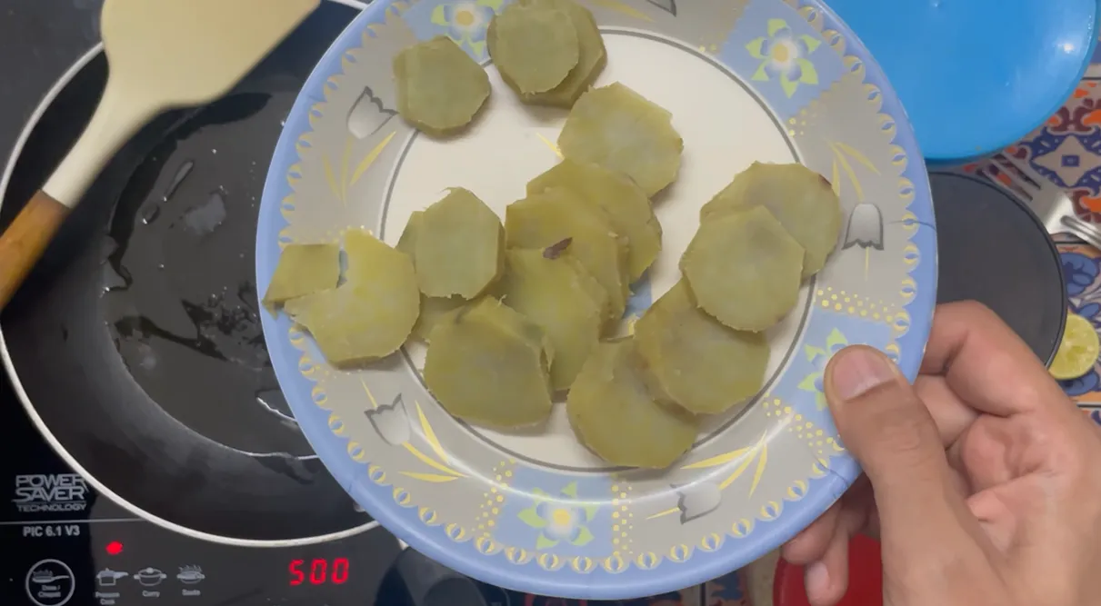 Boiled sweet potato slices on a plate before shallow-frying