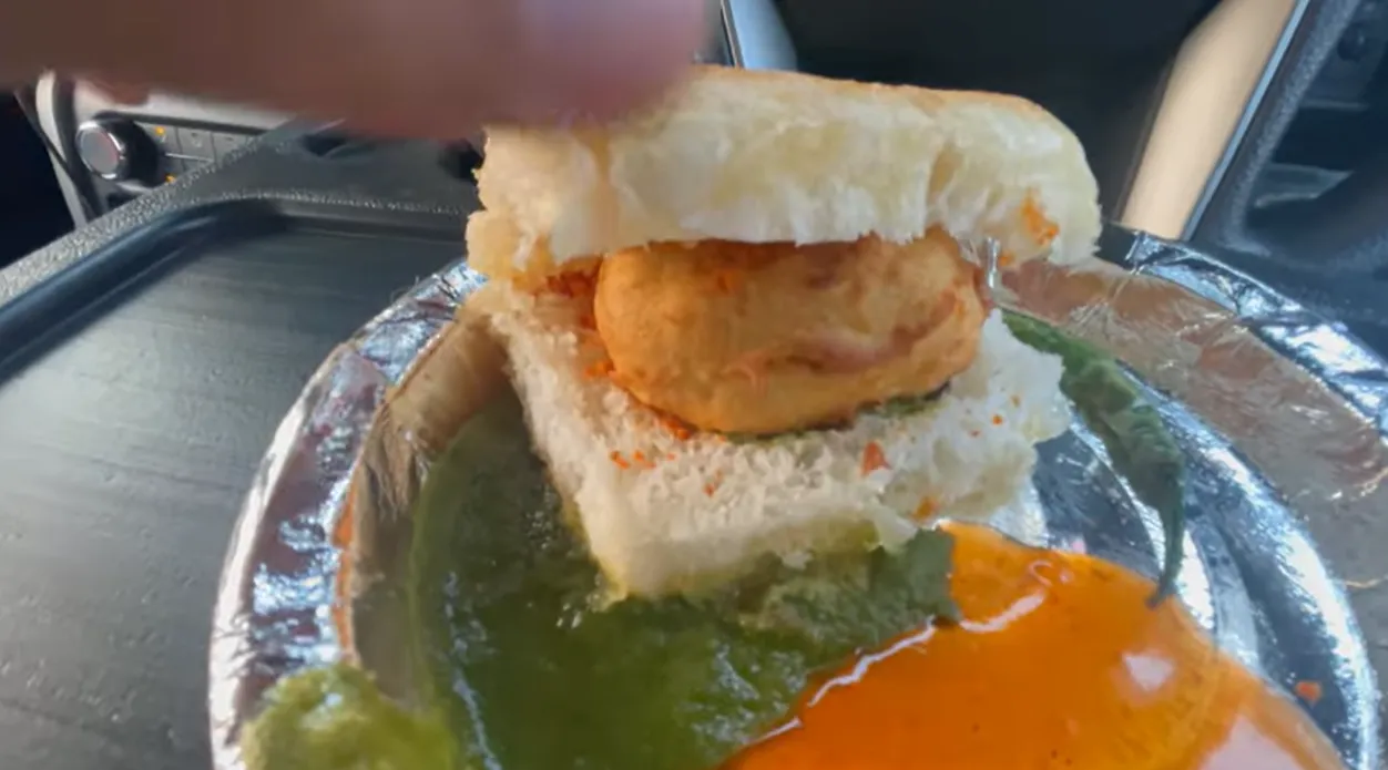 Close view of butter vada pav with green and red chutneys