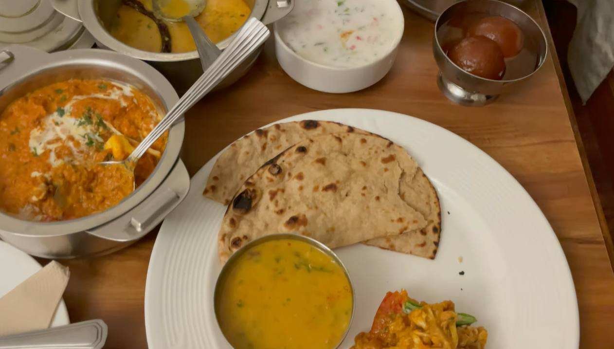 Vegetarian room-service meal with rotis dal vegetables raita and gulab jamun