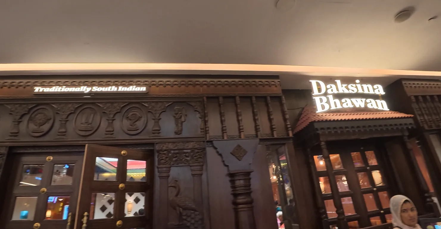 Illuminated Daksina Bhawan restaurant sign and wooden entrance at Elan Epic Mall