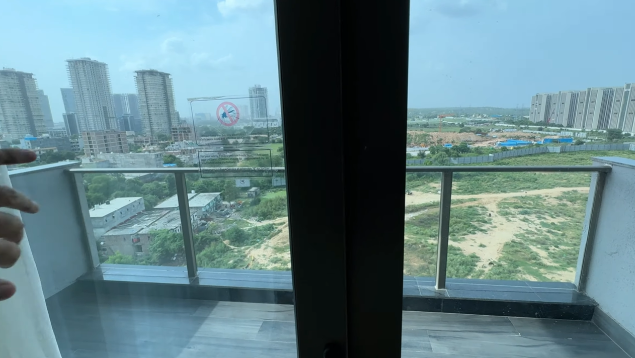 Daytime view of Gurgaon high-rises and open land from the Citadines Paras Square balcony