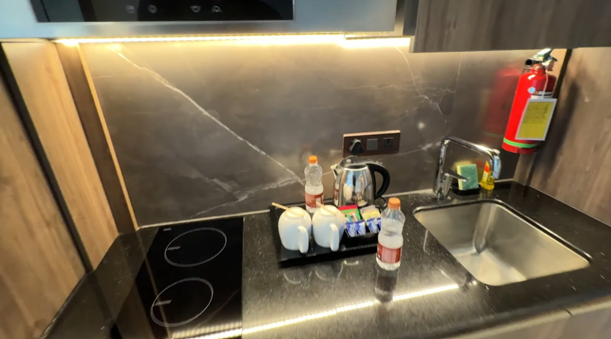 Kitchen counter at Citadines Paras Square with induction cooktop, kettle and sink