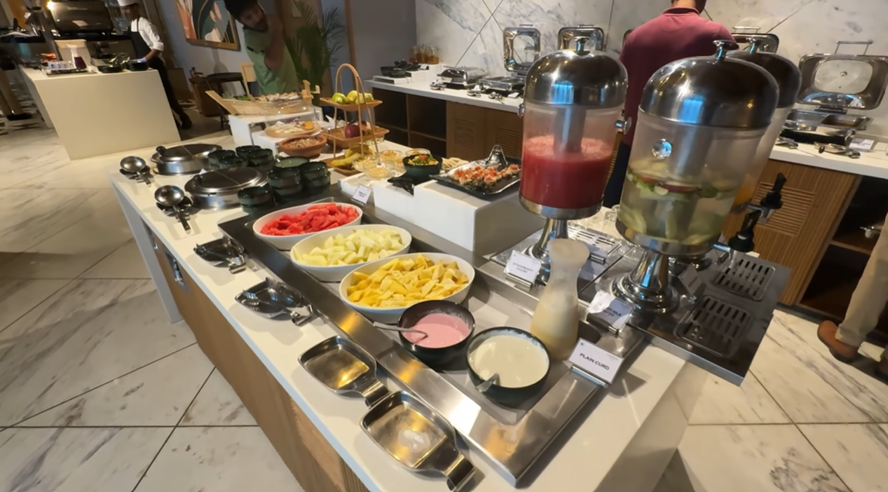 Breakfast buffet spread with fresh fruit, juices and curd at Citadines Paras Square