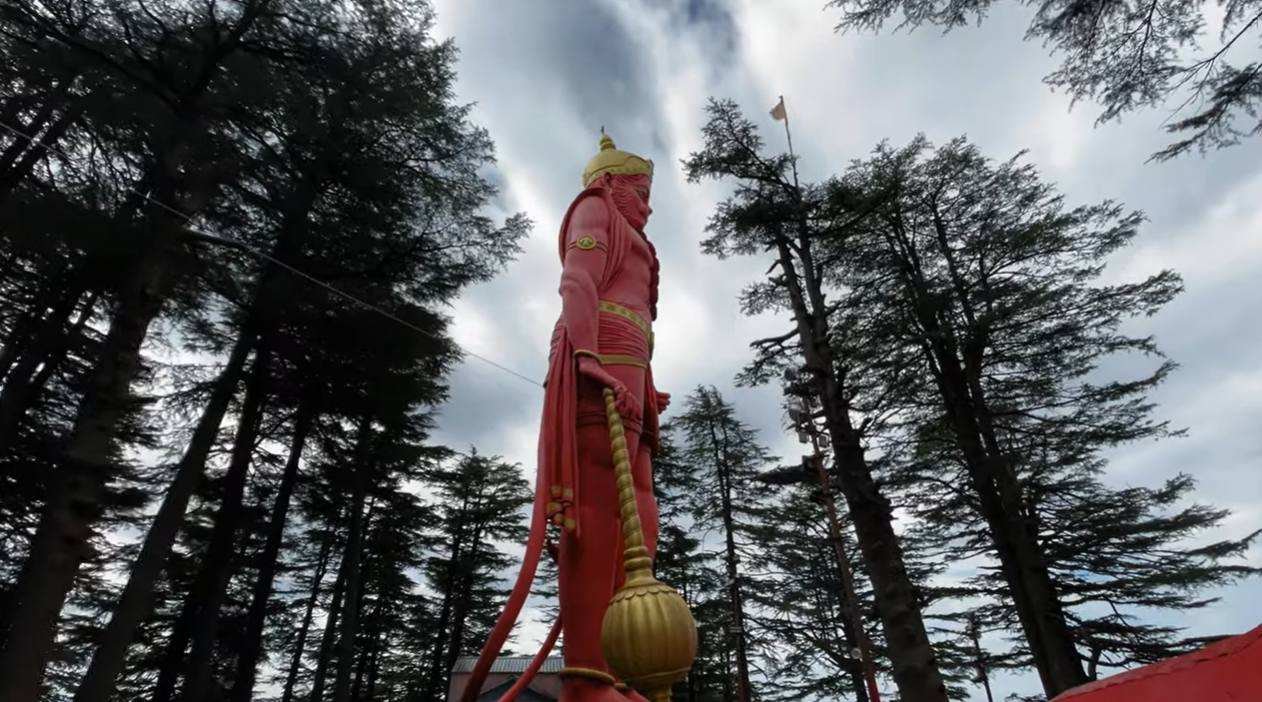 Tall Hanuman statue at Jakhu Temple surrounded by deodar trees