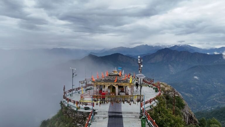 Kartik Swami Temple on a mountain ridge beneath clouds