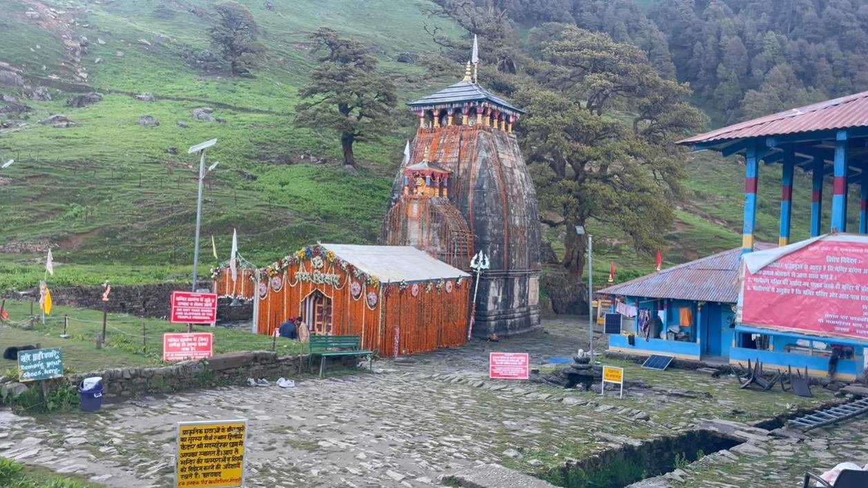Decorated Madhyamaheshwar Temple beside blue buildings