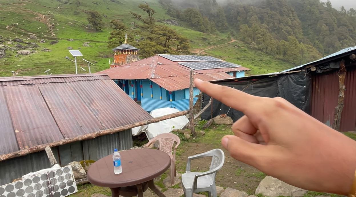 Madhyamaheshwar Temple visible beyond nearby homestay rooftops