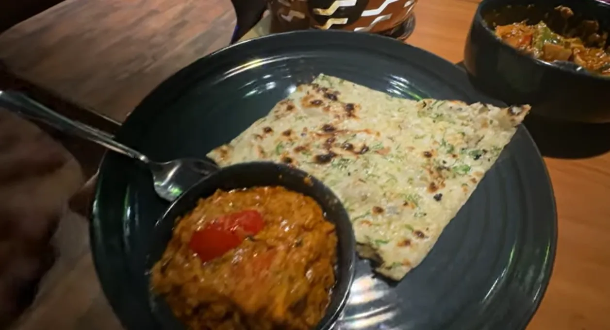 Indian main course with flatbread served on a dark plate at Mongabay Gurgaon