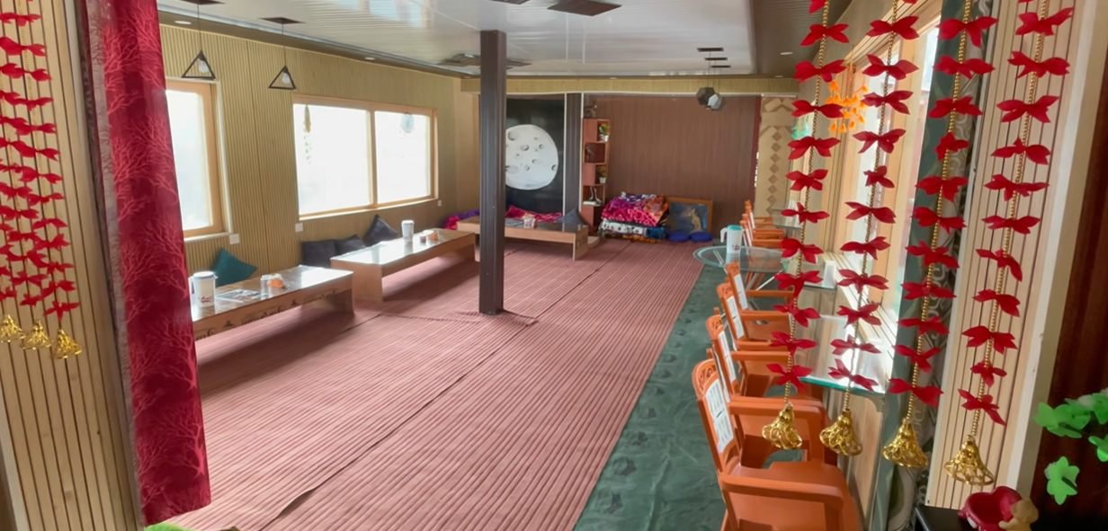 Seating and windows inside Moon Rock Cafe near Chopta