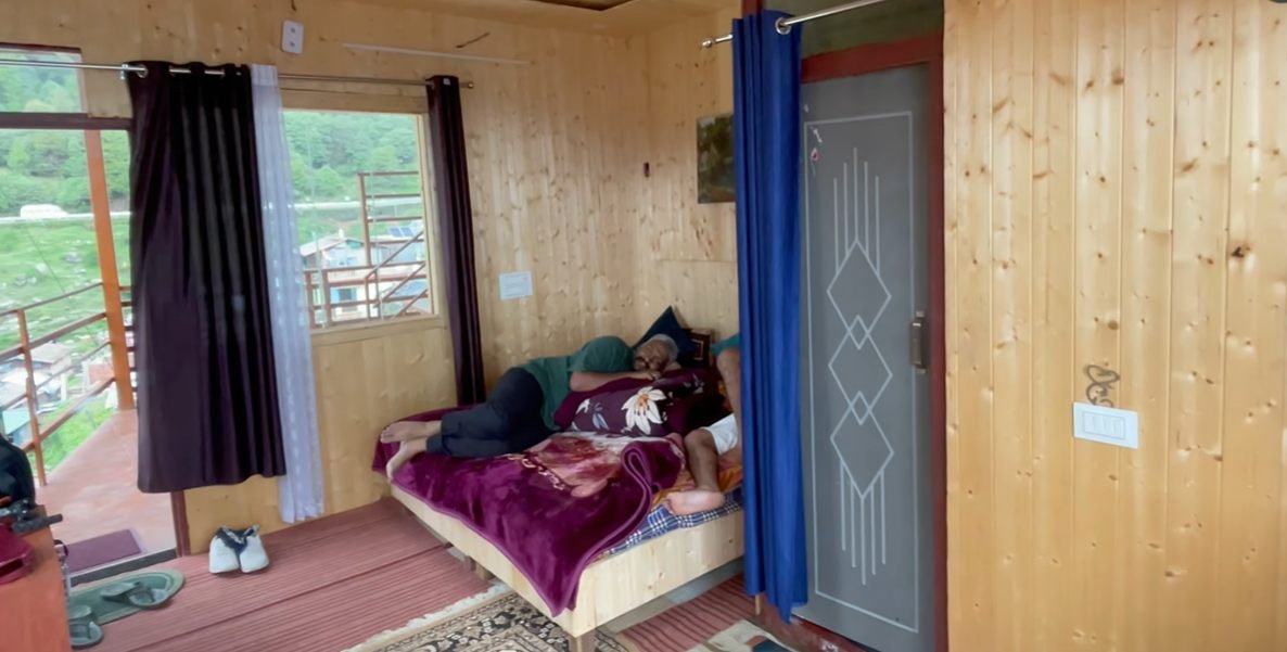 Wood-panelled room with bed at Moon Rock Cafe and Stay
