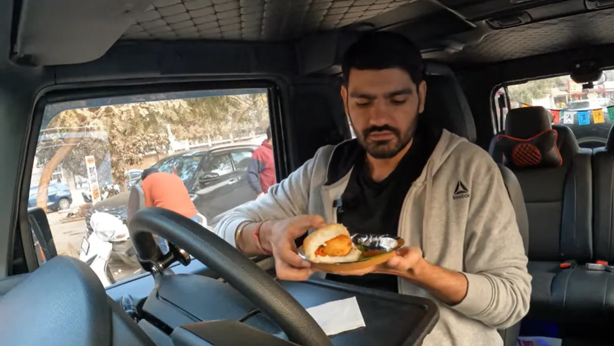 Naveen preparing to taste butter vada pav inside his car