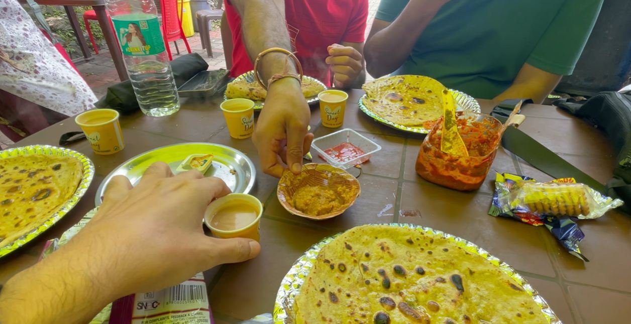 Parathas, tea and snacks on a table after the Kartik Swami trek