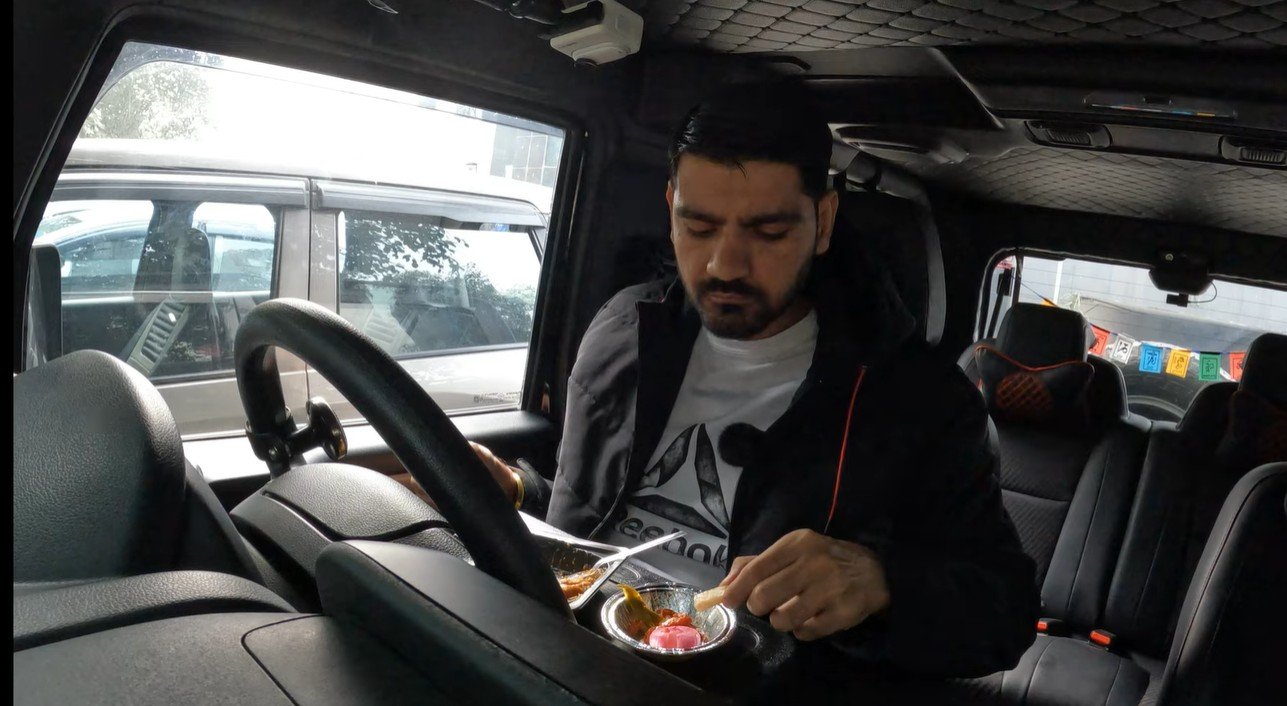 Naveen tasting bheega kulcha inside his parked car