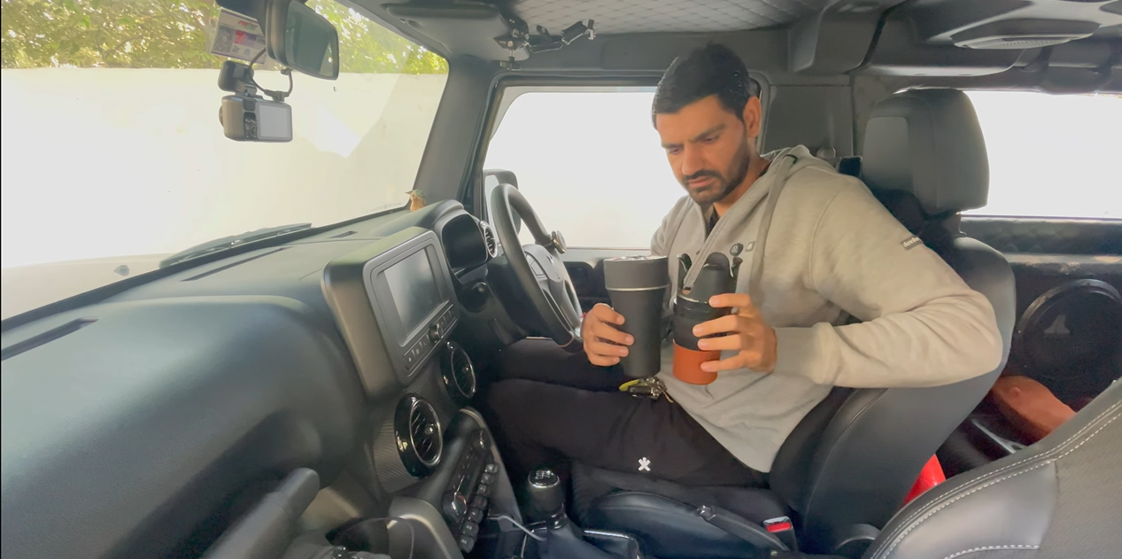 Reffair AX50 car air purifier compared with two travel mugs inside the vehicle