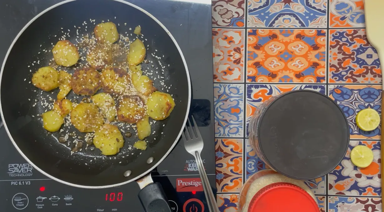Golden sweet potato slices with sesame seeds and jaggery in the pan