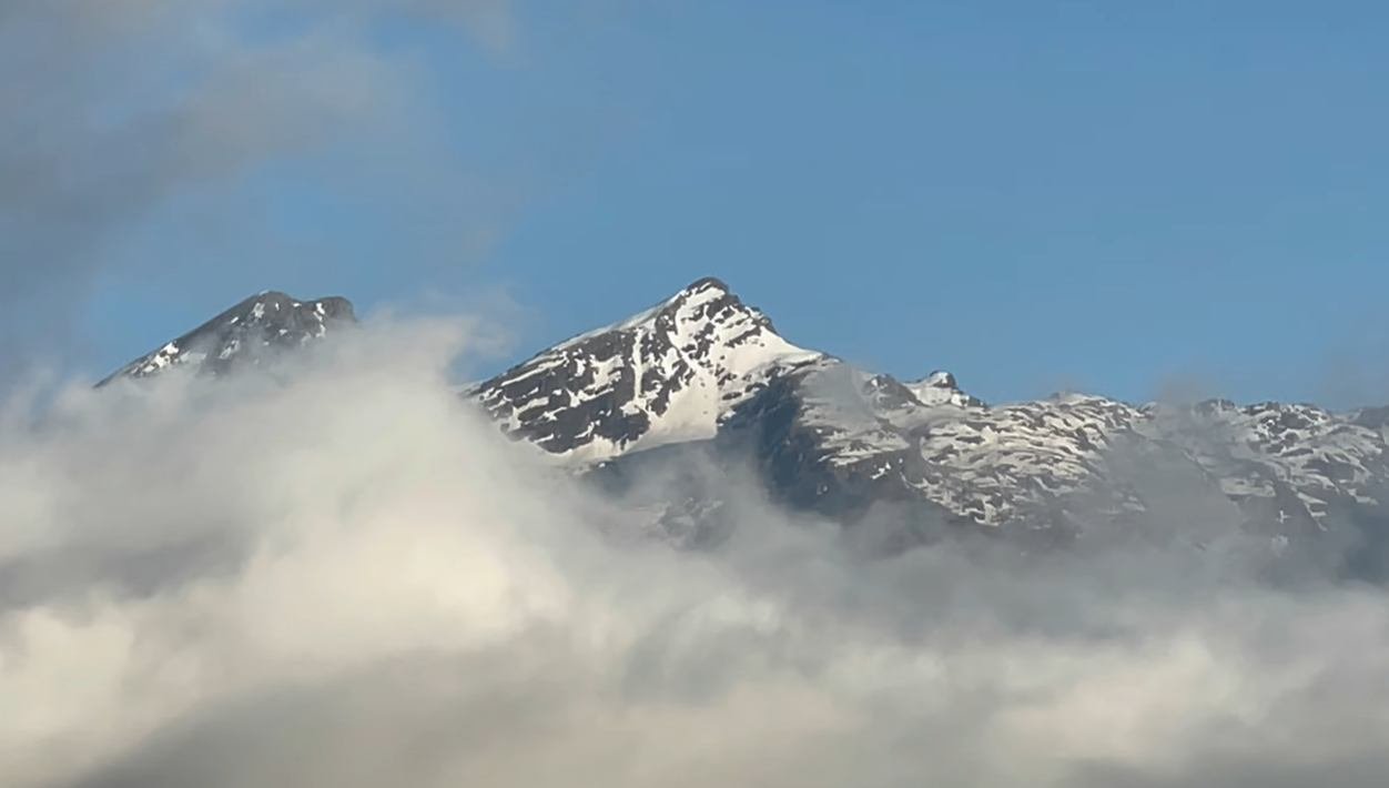 Snow on mountain peaks above clouds near Madhyamaheshwar