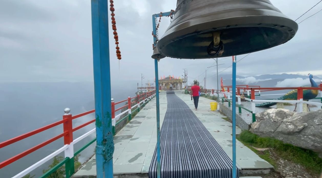 Large temple bell above the walkway to Kartik Swami shrine