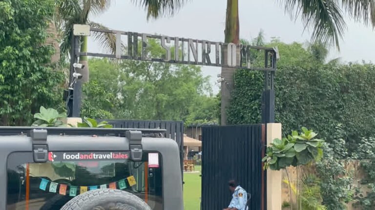 The Sunroom entrance gate at Palam Farms with the Foodandtraveltales vehicle in front