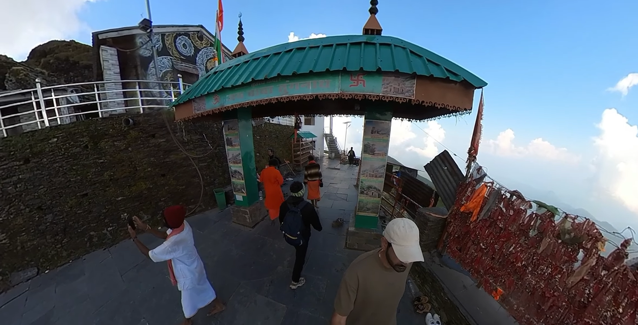 Green-roofed gateway and stone path in the Tungnath Temple complex