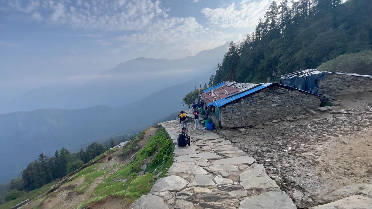 Stone path passing a small hillside shop on the Tungnath route